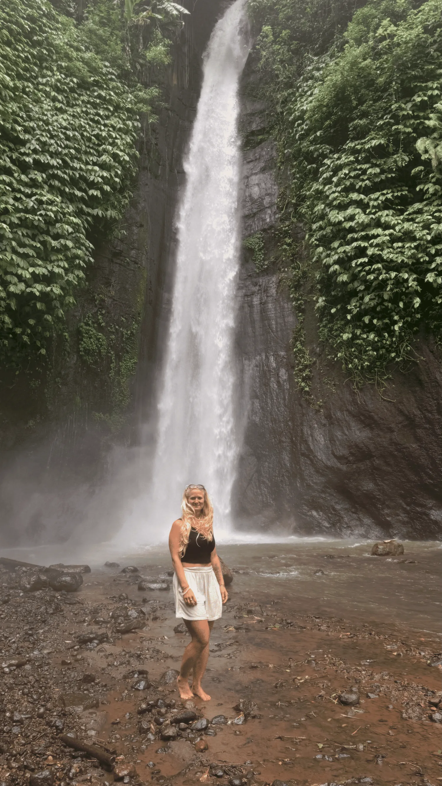 Kathy an einem Wasserfall im tropischen Grün